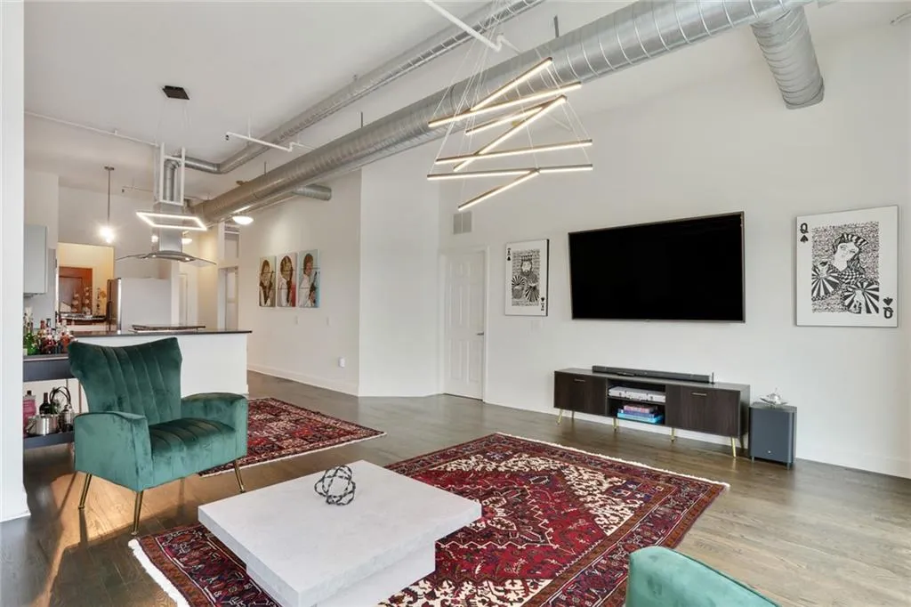 Living room with a high ceiling and dark wood-style flooring