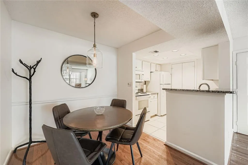 Dining room featuring light wood-style floors, a textured ceiling, and recessed lighting