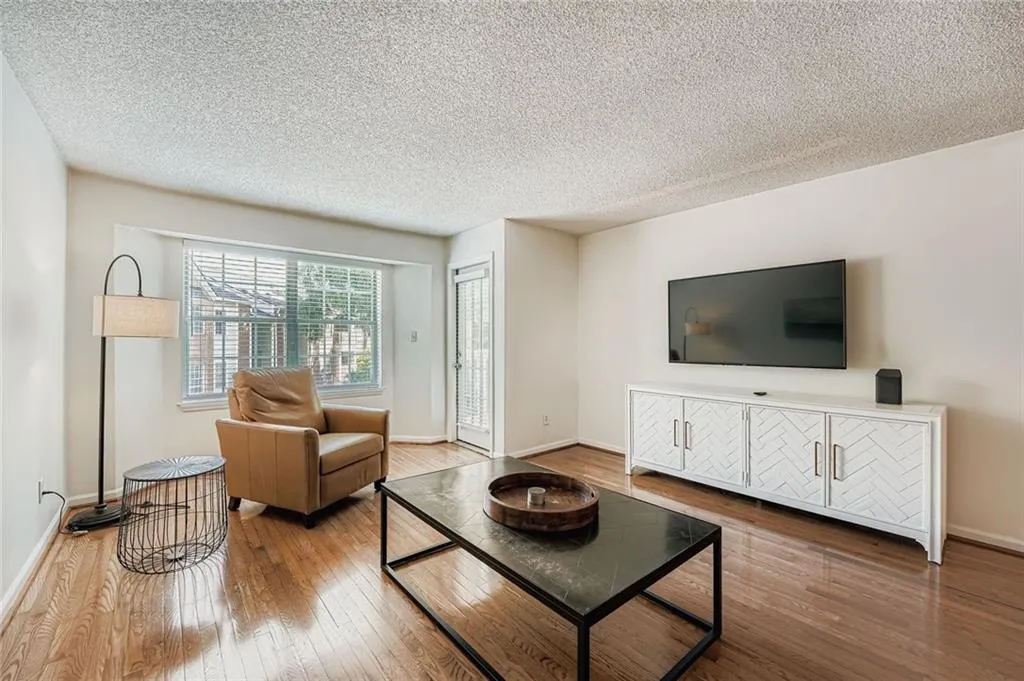 Living room with wood-type flooring and a textured ceiling