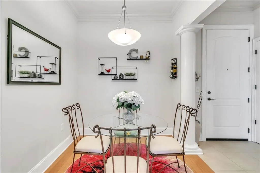 Dining area with decorative columns, hardwoods and crown molding