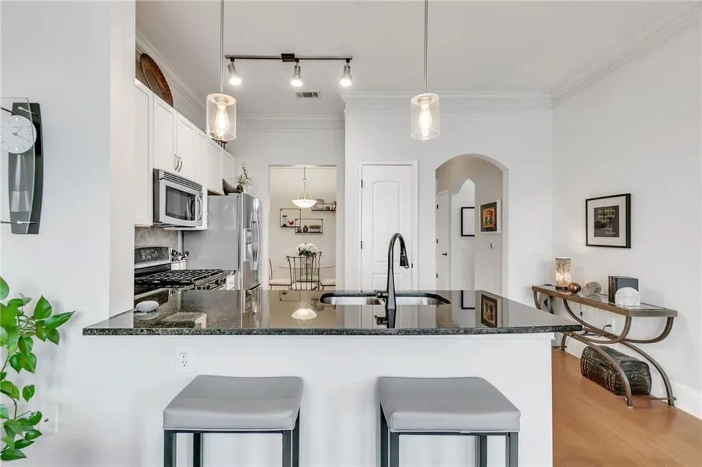 Breakfast counter, pantry, and white refinished cabinetry