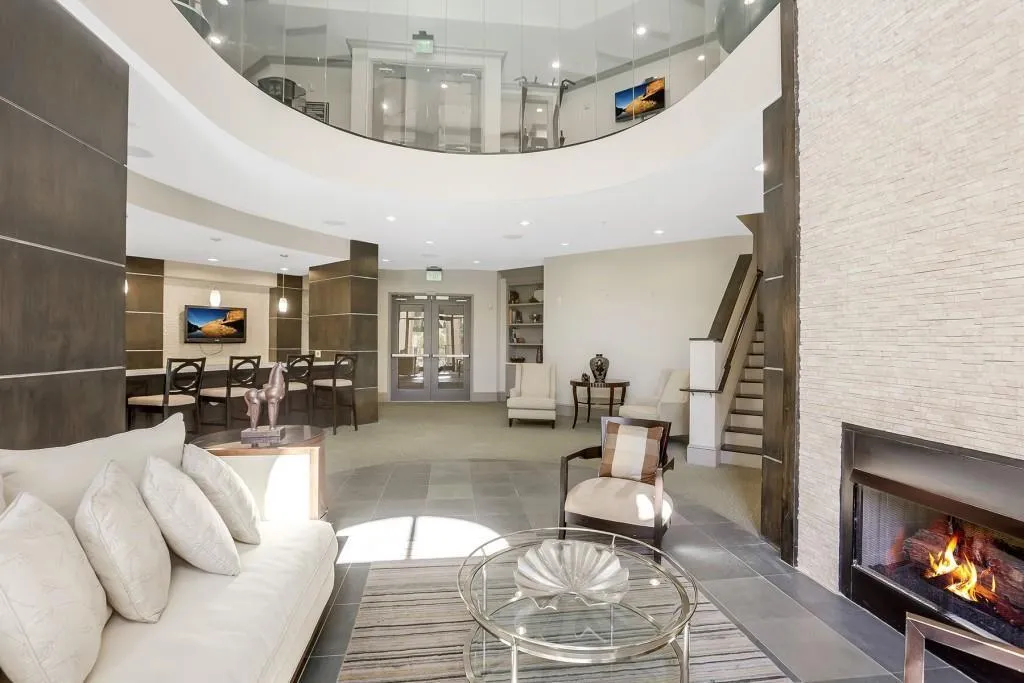Bright clubroom has towering ceiling and double-sided fireplace