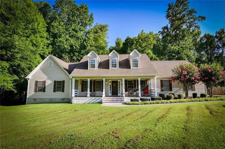Ranch-style exterior with light-colored siding and a covered front porch featuring white columns