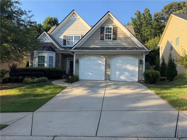 Two-story home with a two-car garage, bay window, and a gabled roofline