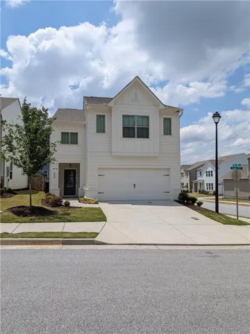 Two-story residence with a white exterior, attached two-car garage, and a concrete driveway