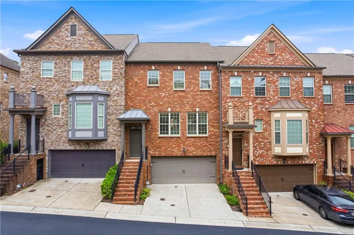 Townhome exterior featuring varied brick and stone facades with architectural gables
