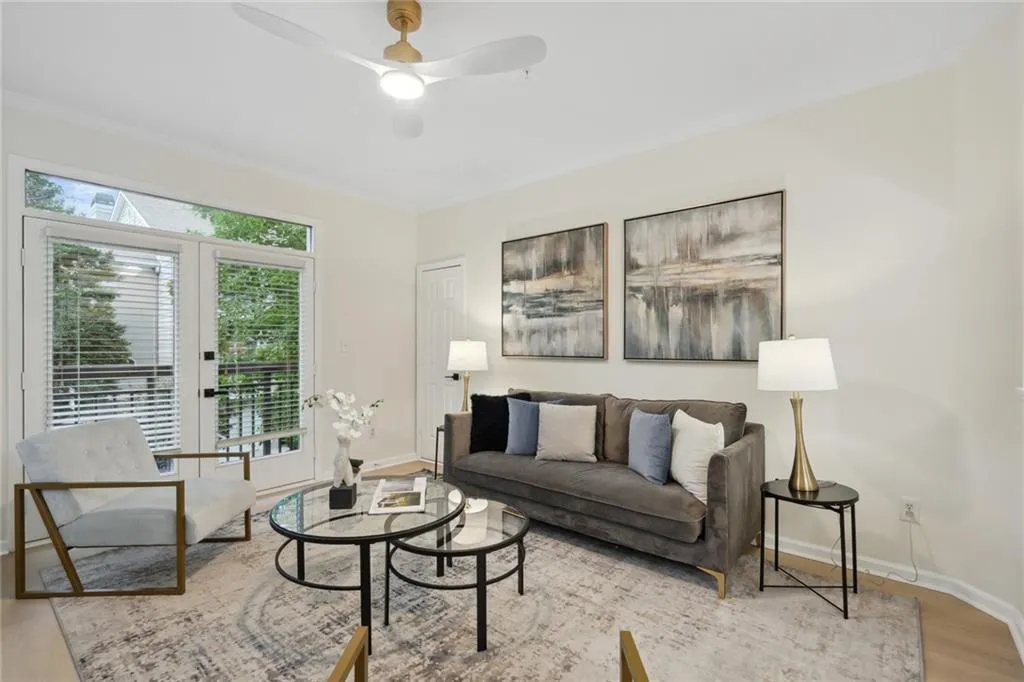 Living room featuring light hardwood / wood-style flooring, ceiling fan, french doors, and crown molding