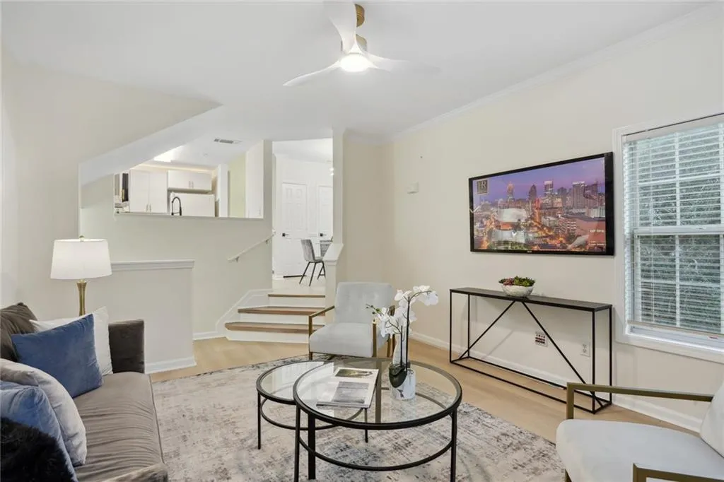 Living room featuring ornamental molding, plenty of natural light, ceiling fan, and light wood-type flooring