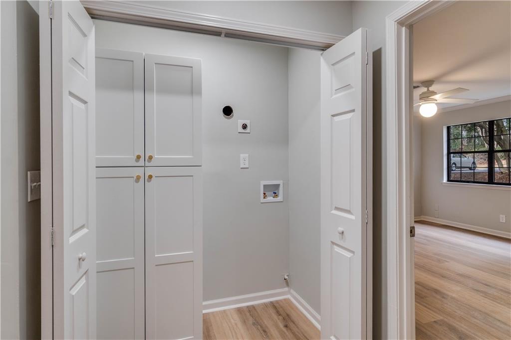 Laundry room featuring hookup for an electric dryer, light hardwood / wood-style flooring, and ceiling fan