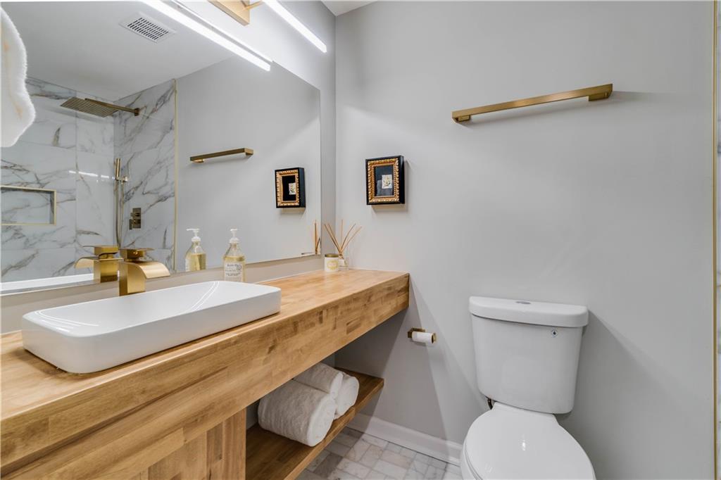 Bathroom featuring toilet, vanity, and tile flooring