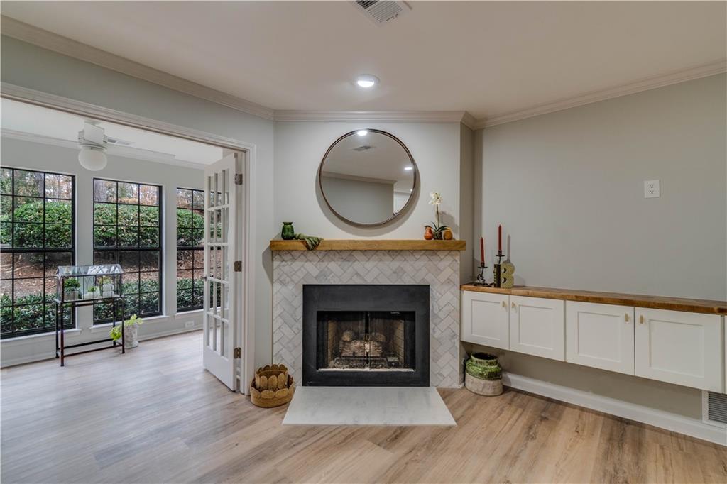 Living room featuring crown molding, light hardwood / wood-style floors, a fireplace, and ceiling fan