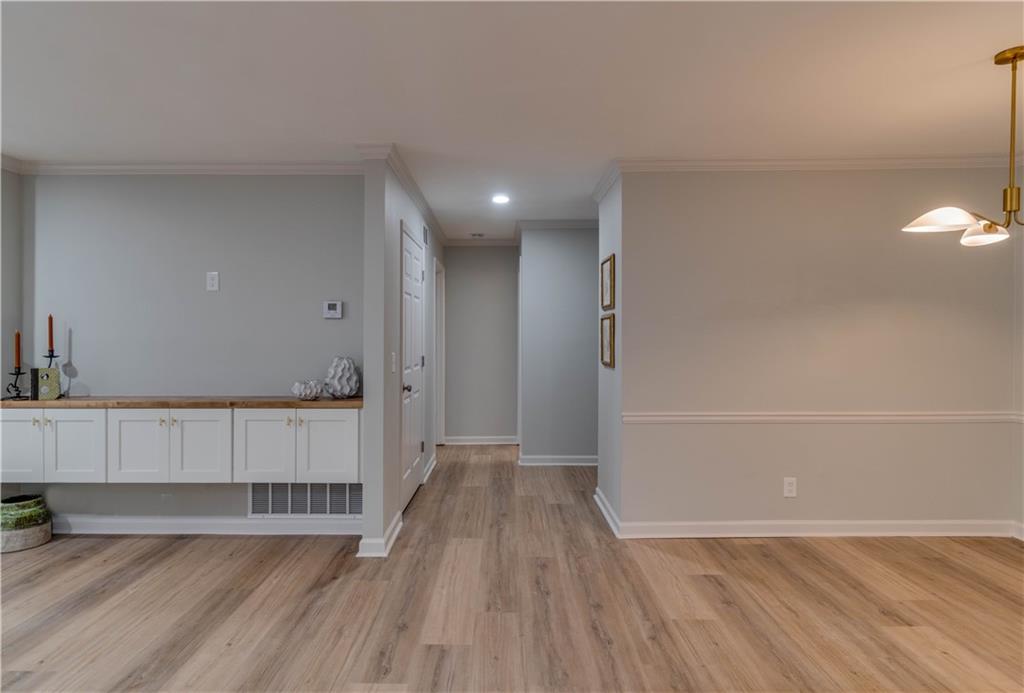 Hall featuring ornamental molding and light wood-type flooring