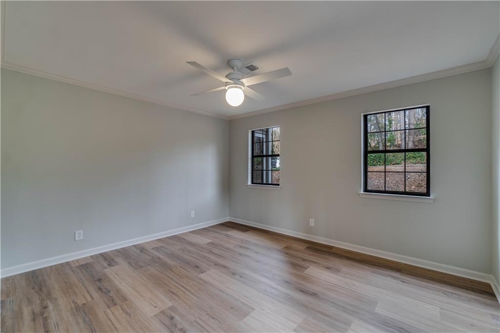 Unfurnished room with ornamental molding, light hardwood / wood-style floors, and ceiling fan