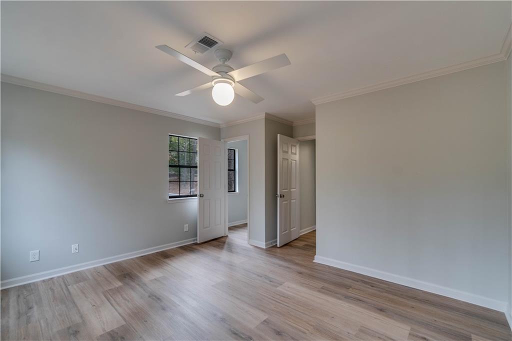 Spare room featuring ornamental molding, light wood-type flooring, and ceiling fan