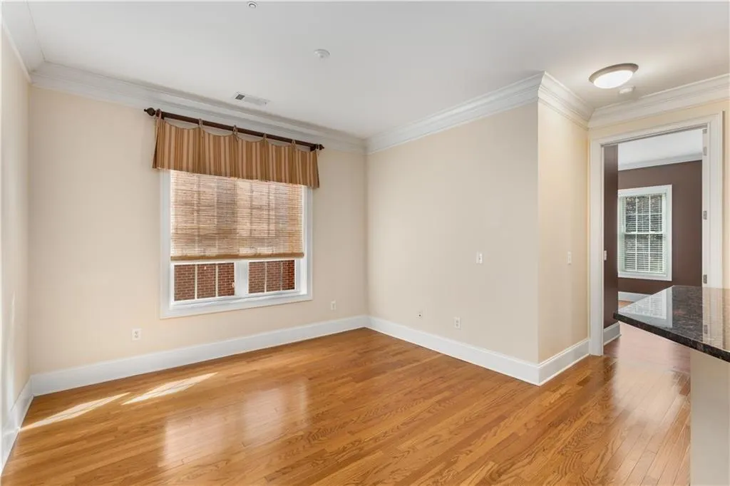 The multi-purpose Keeping Room has windows providing natural light to that room and to the Kitchen.  The 2 secondary bedrooms with ensuite bathrooms are located on both sides of the Keeping Room.  The background reflects the open door to one of those bedrooms.
