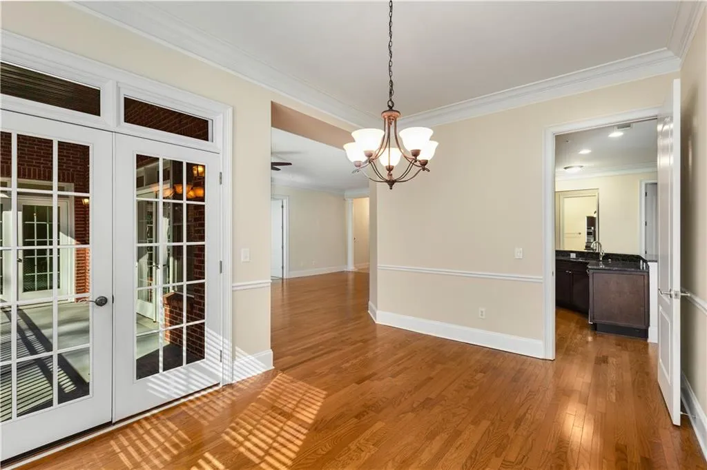 This dining Room photo shows the Balcony and a background view of the Living Room and open door to the Kitchen.
