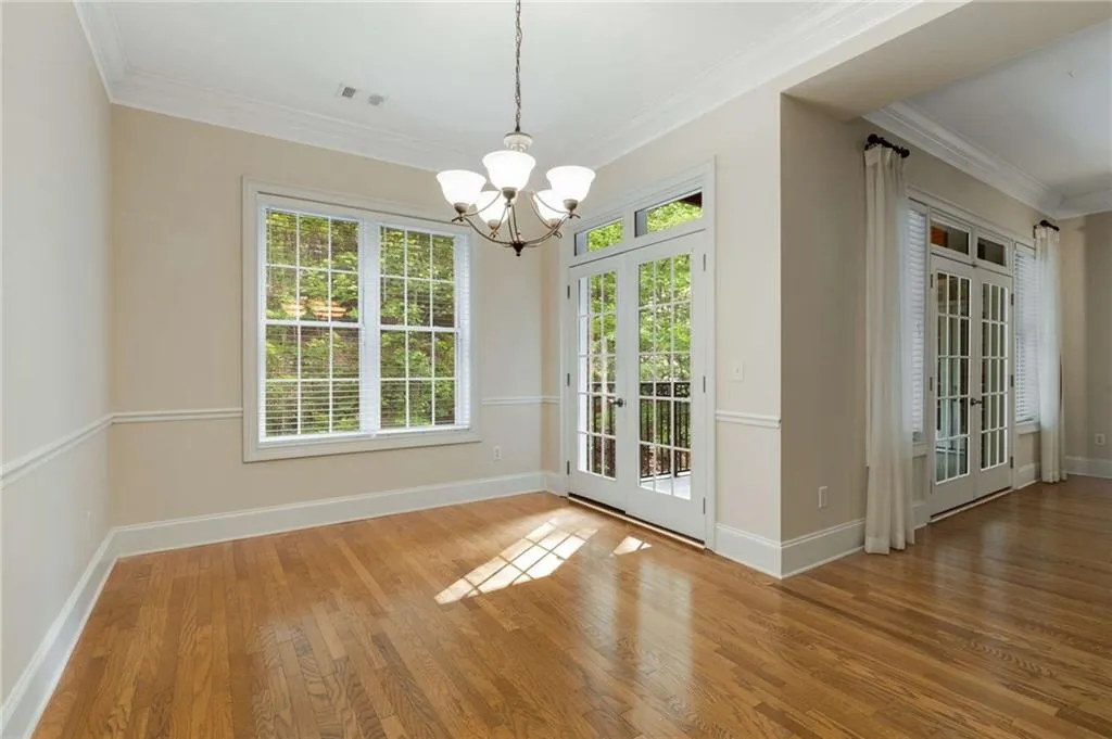The Dining Room has glass French doors which open to the covered balcony and a large opening to the living room on the right.