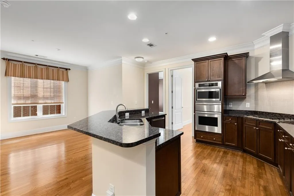 The Kitchen and Keeping Room with windows and doors to the Dining Room and 2nd Bedroom in the background.  The Kitchen has beautiful granite countertops.  The upper countertop will accommodate bar chairs/stools for eating or sitting at the Island which has a double stainless steel sink with a new faucet and Bosch dishwasher.