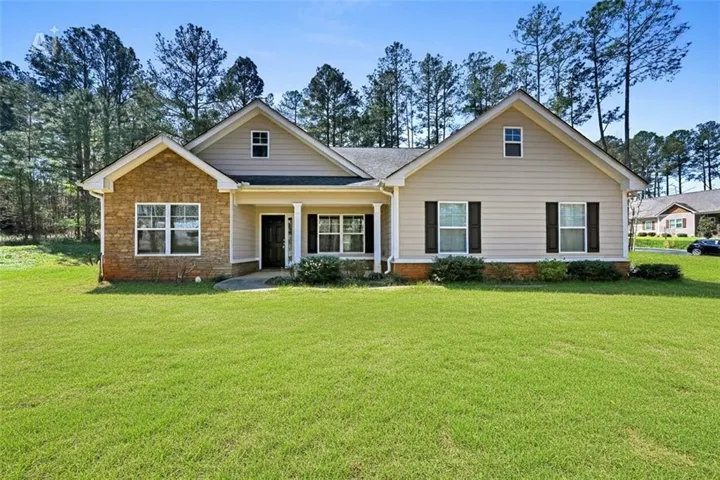 View of front of property featuring covered porch, a front yard, and roof with shingles