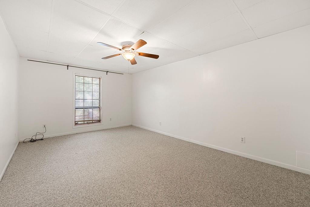Unfurnished room with light carpet and ceiling fan Unfurnished room with light carpet and ceiling fan