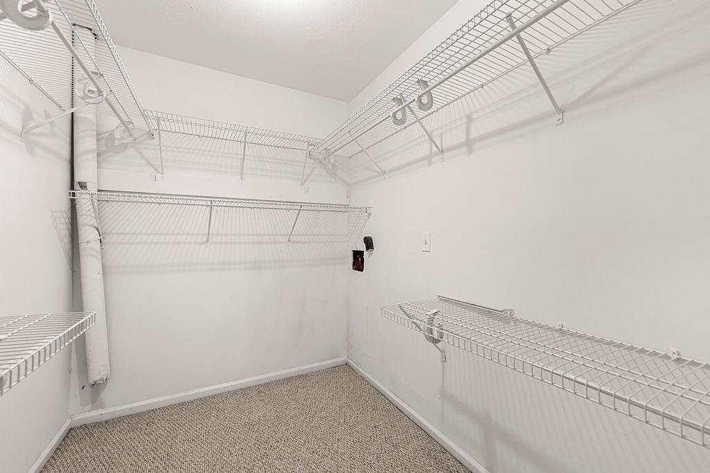 Walk in closet featuring light carpet Walk in closet featuring light carpet