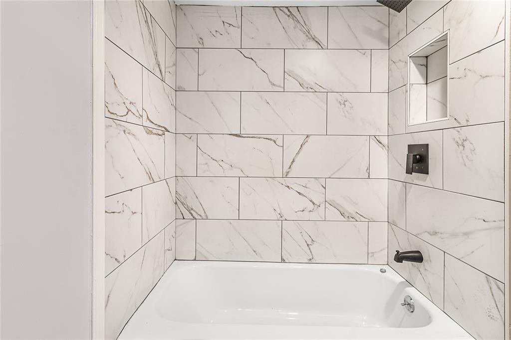 Bathroom featuring tiled shower / bath combo Bathroom featuring tiled shower / bath combo
