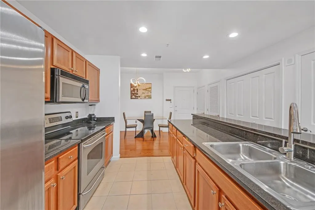 Kitchen featuring stainless steel appliances, sink, and light tile patterned floors