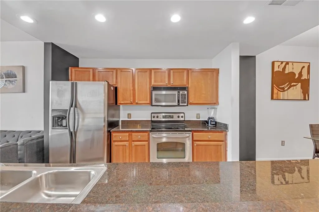 Kitchen with dark stone countertops, sink, and stainless steel appliances