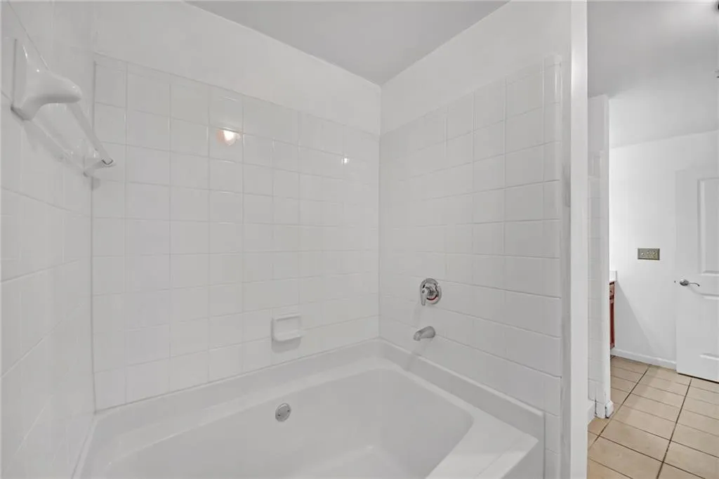 Bathroom featuring tiled shower / bath combo and tile patterned floors