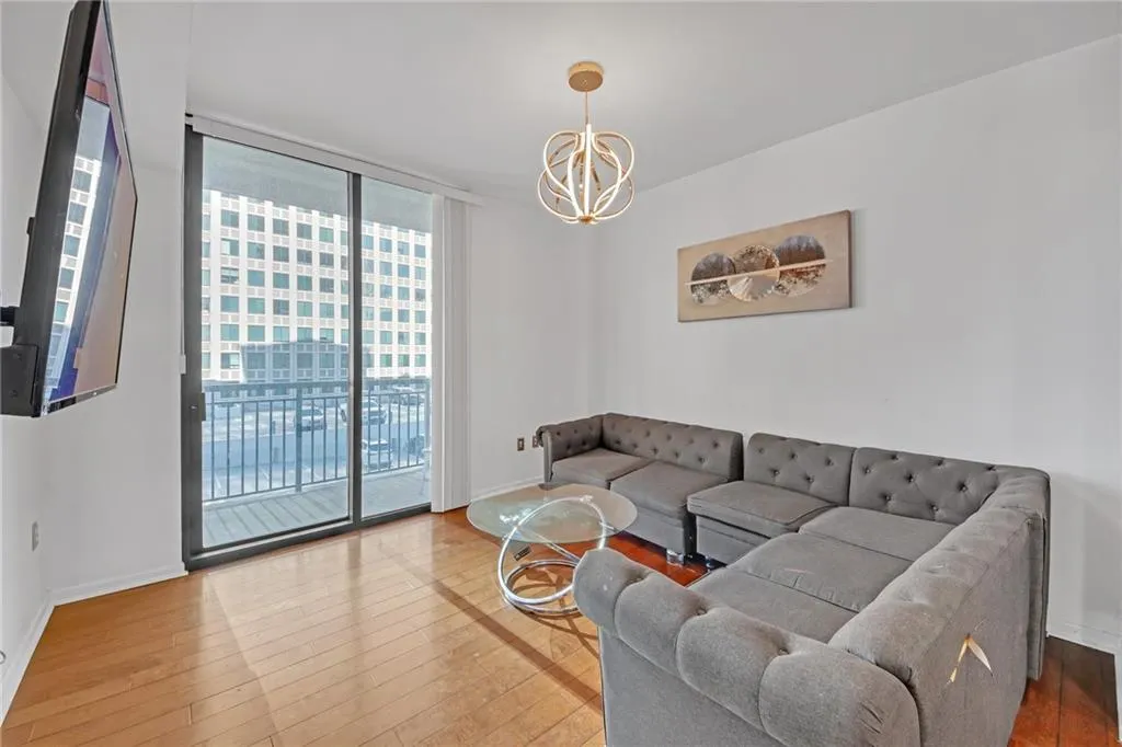 Living room featuring hardwood / wood-style floors, a notable chandelier, and expansive windows