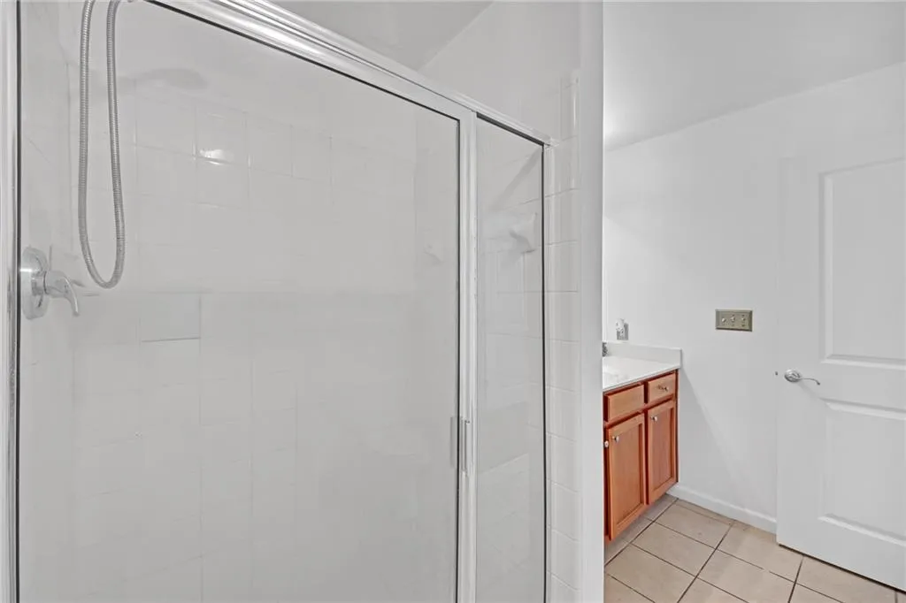 Bathroom with vanity, tile patterned flooring, and walk in shower
