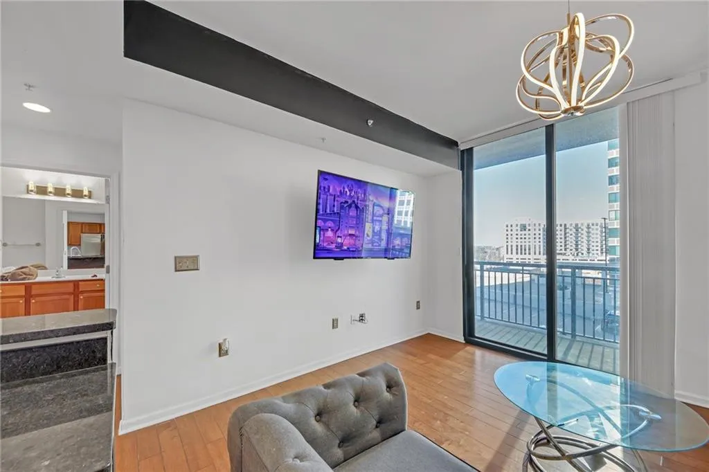 Living room with floor to ceiling windows, an inviting chandelier, and light hardwood / wood-style floors