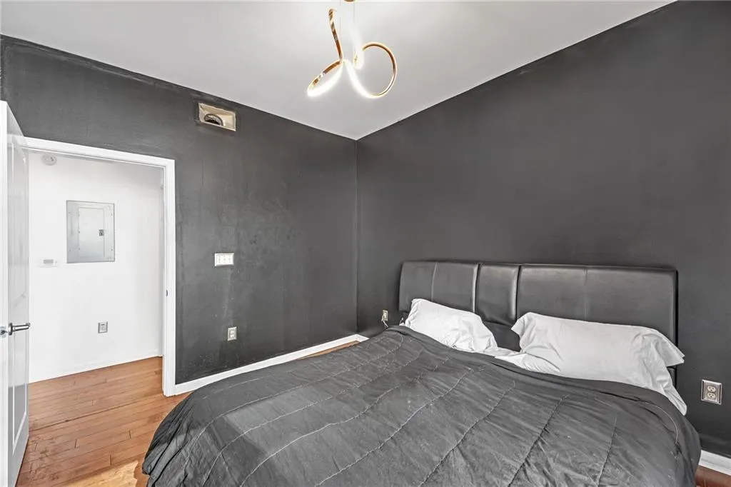 Bedroom with wood-type flooring and electric panel