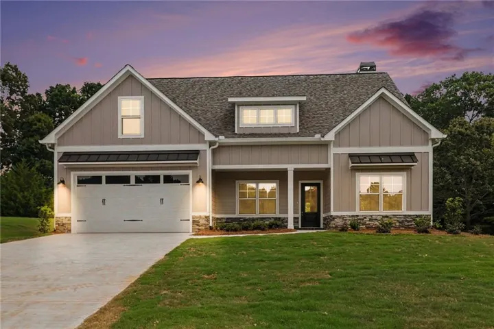 Craftsman-style home featuring a two-car garage, stone façade, board and batten siding, and a covered entry