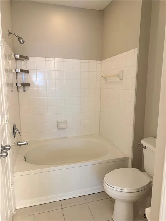 Full bathroom with tile patterned floors and washtub / shower combination