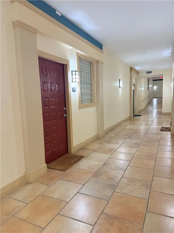 Hall featuring baseboards and light tile patterned floors