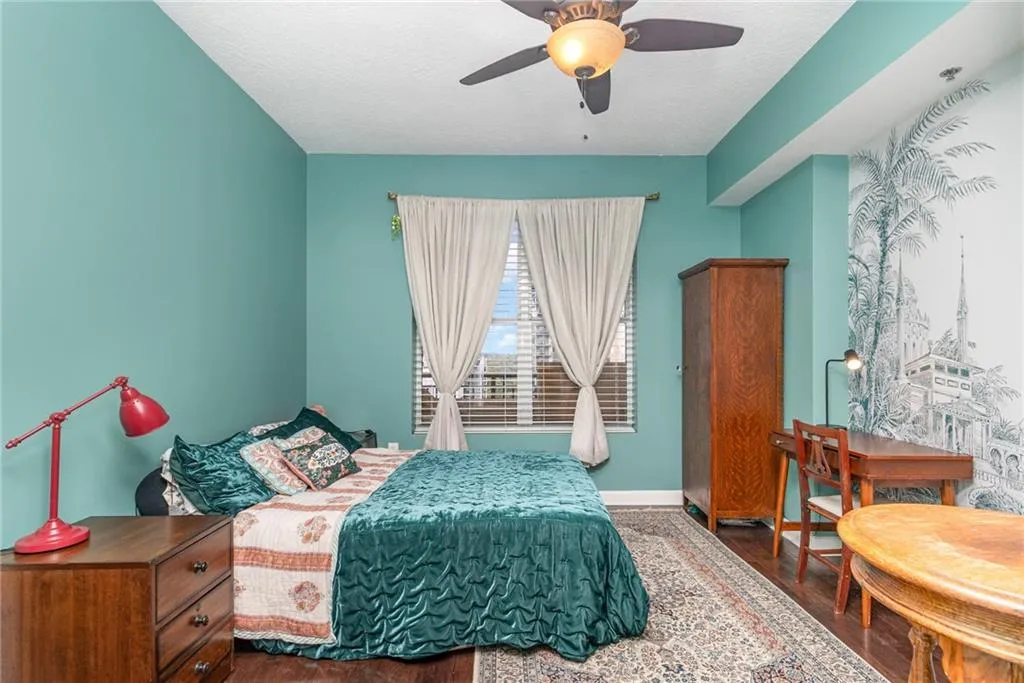 Bedroom featuring dark wood finished floors, ceiling fan, and a textured ceiling