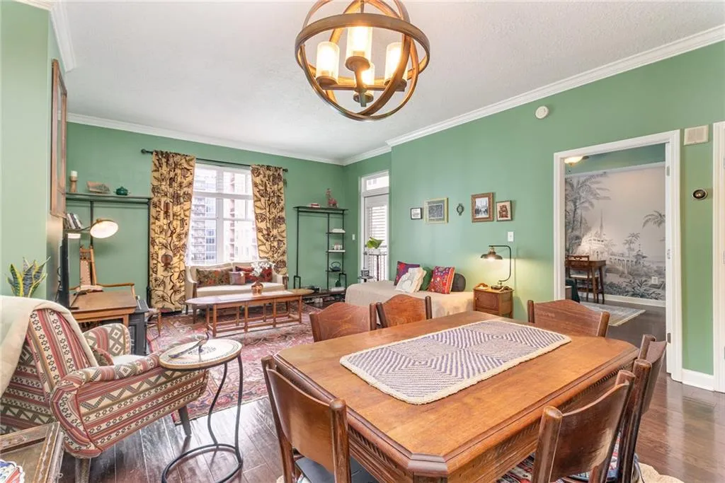 Dining space featuring ornamental molding, a chandelier, dark wood finished floors, and a textured ceiling