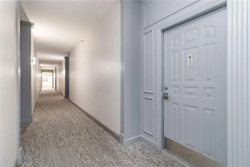 Hallway with baseboards and carpet floors