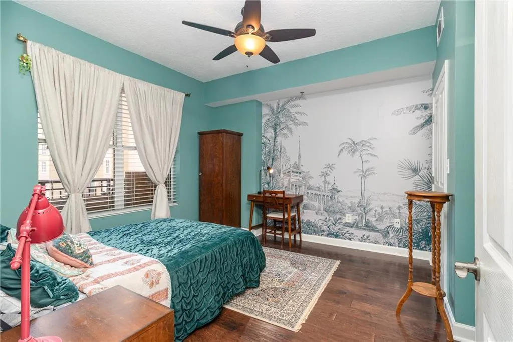 Bedroom with dark wood-style floors, ceiling fan, and a textured ceiling