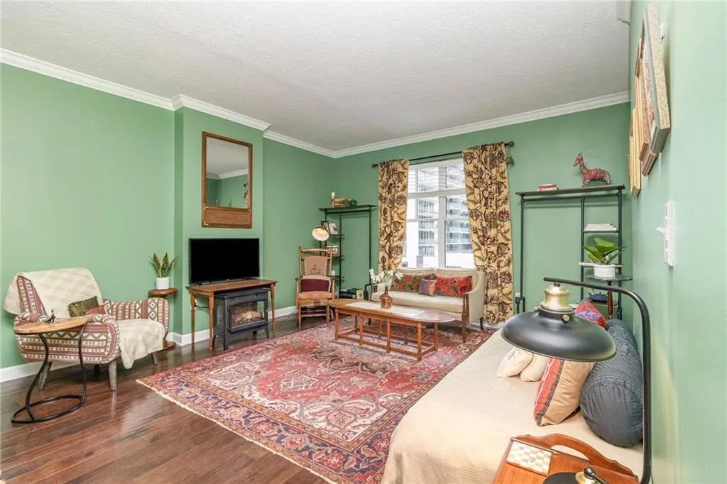 Living area featuring crown molding, wood finished floors, and a textured ceiling