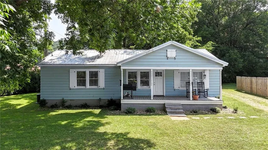 Light blue siding exterior with a white front door and covered porch