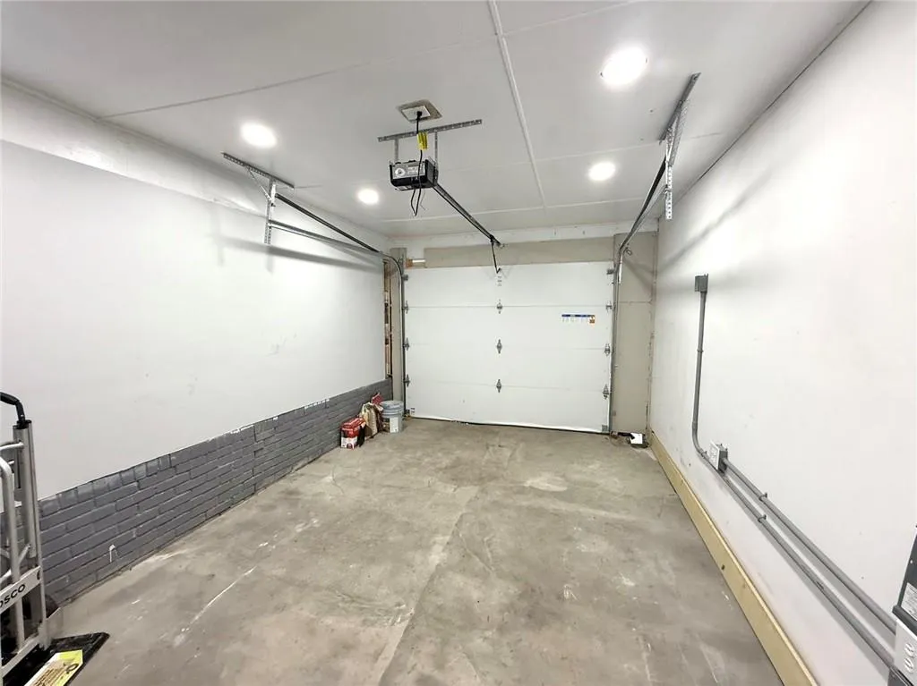 Garage featuring a garage door opener and recessed lighting