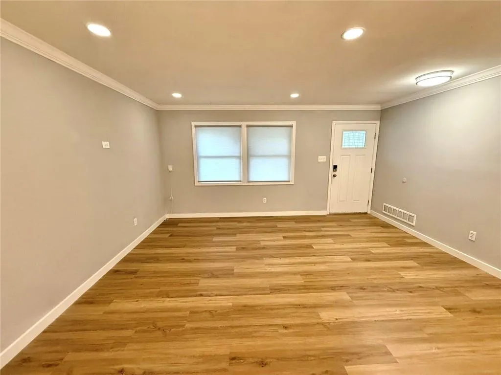 Foyer entrance with crown molding, recessed lighting, and light wood finished floors