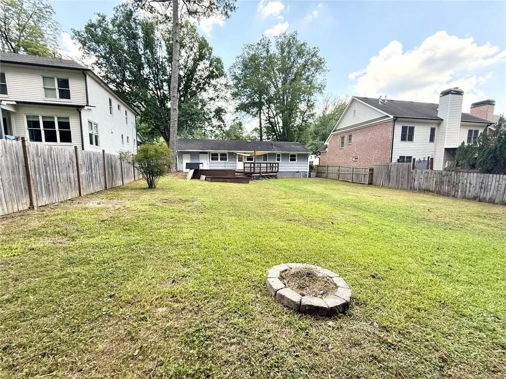 Fenced backyard featuring a deck