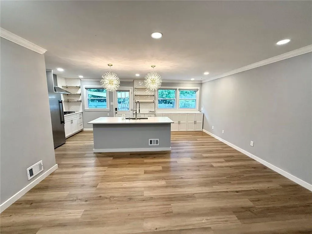 Kitchen with open shelves, a chandelier, crown molding, freestanding refrigerator, and recessed lighting