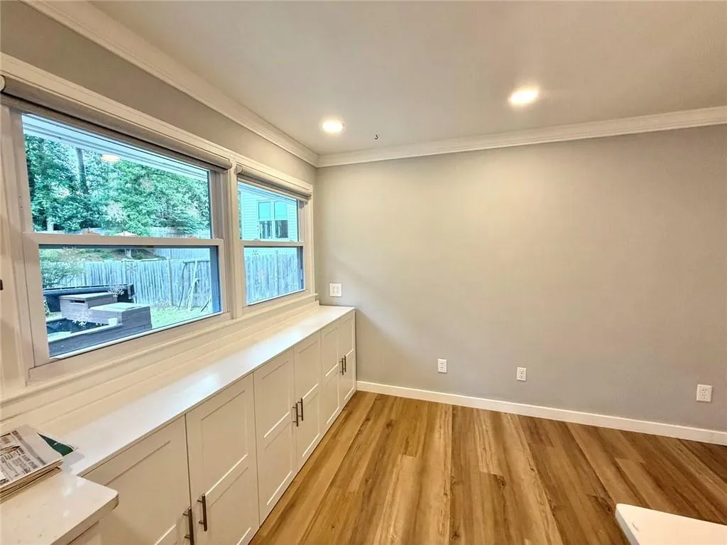 Unfurnished room with light wood-style flooring, crown molding, and recessed lighting