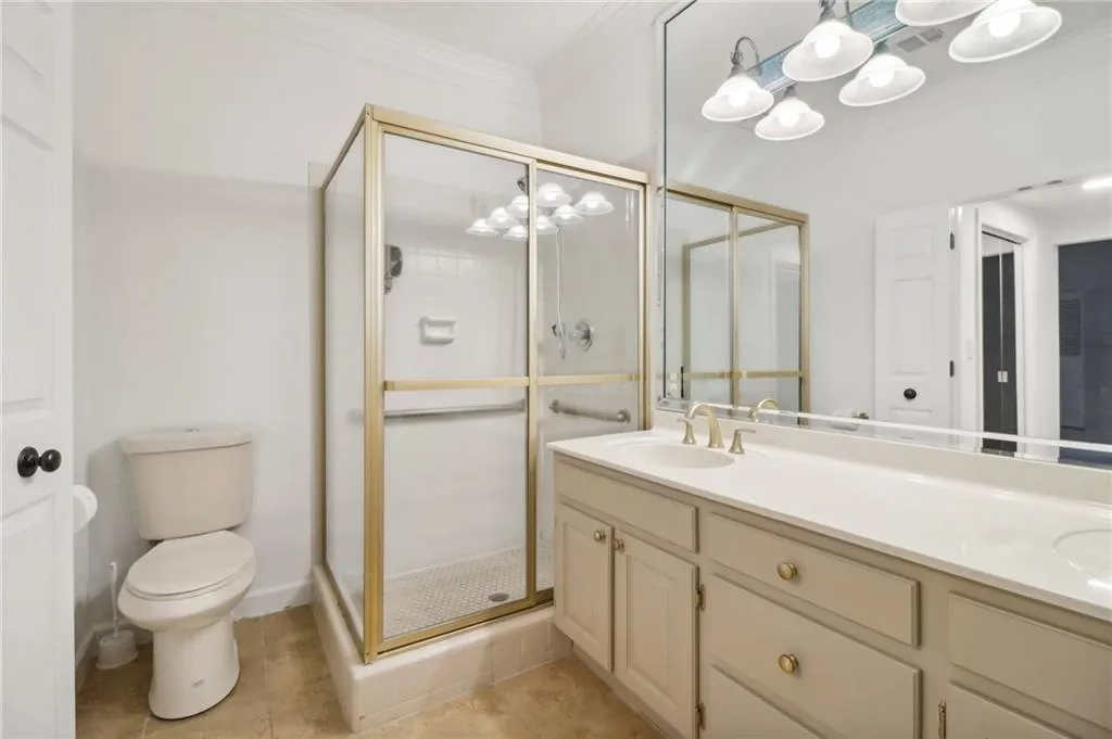 Owner's ensuite bath with double vanities and glass enclosed shower