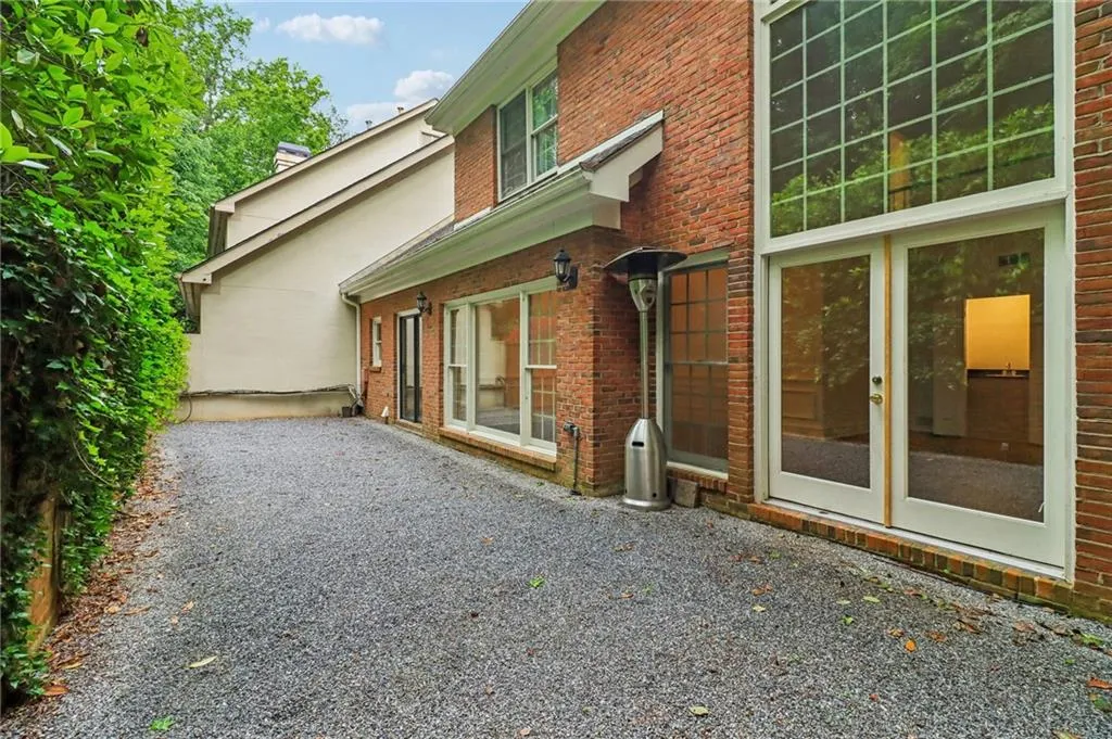 Brick courtyard wall and tall shrubs offer privacy but also ample space for entertaining, a safe kid/pet play area, enough sun for a container garden