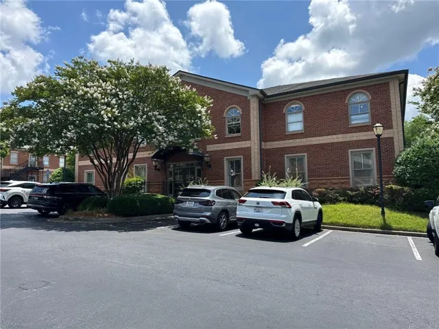 View of building exterior with uncovered parking